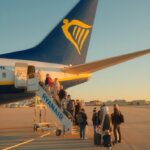 Travelers board a Ryanair plane at sunset in Porto, capturing the essence of budget travel.
